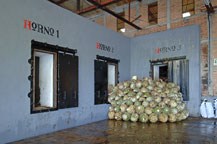 agave piñas or pineapples stacked in front of an oven waiting to be cooked 