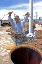 A basket of burning wood is placed a white oak barrel to char it for aging at Tres Mujeres Tequila